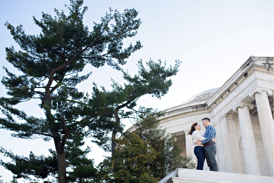 A man and woman hold each other in front of the lincoln memorial in DC.